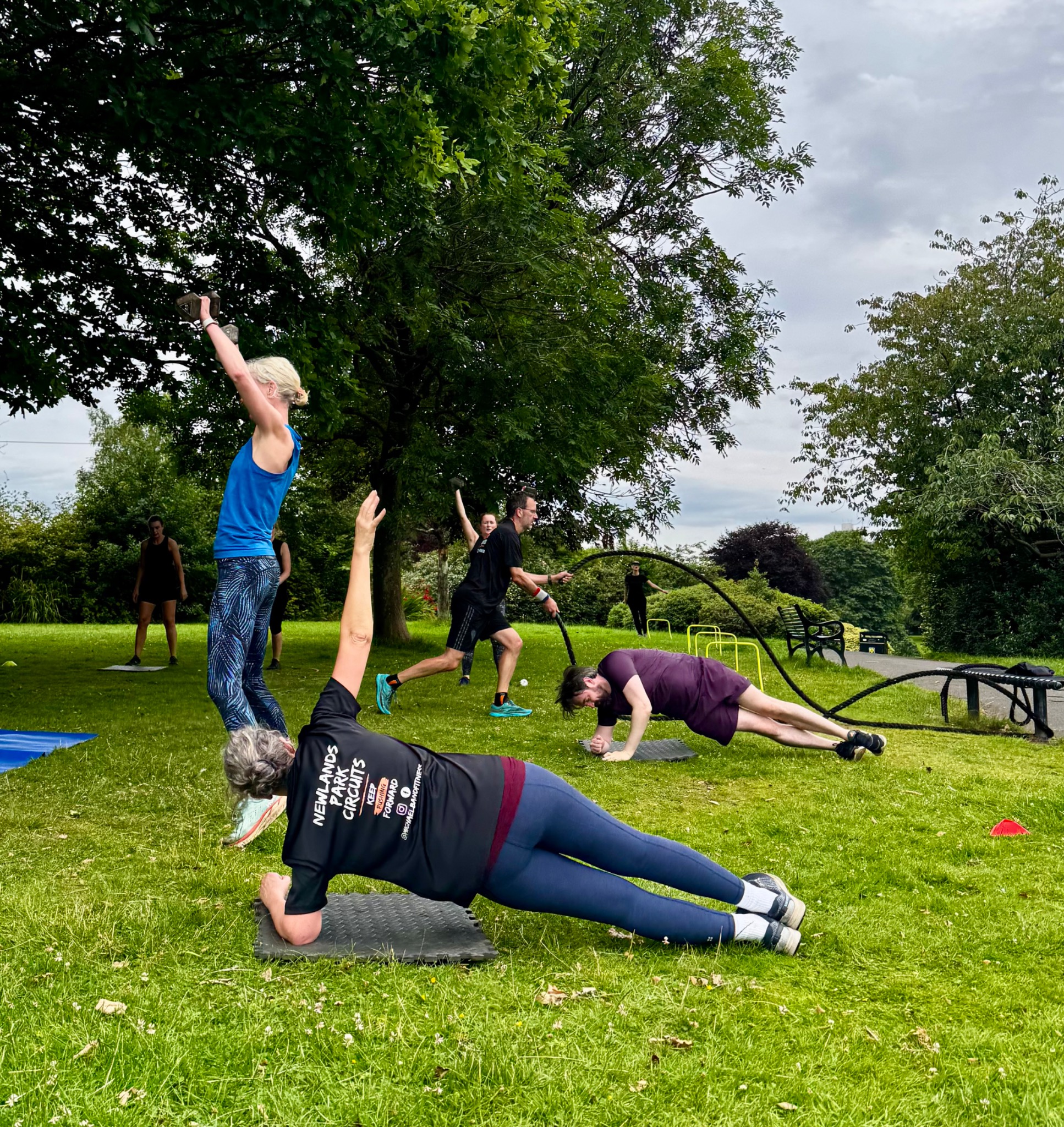 Participants working through different outdoor circuit exercises on the grass