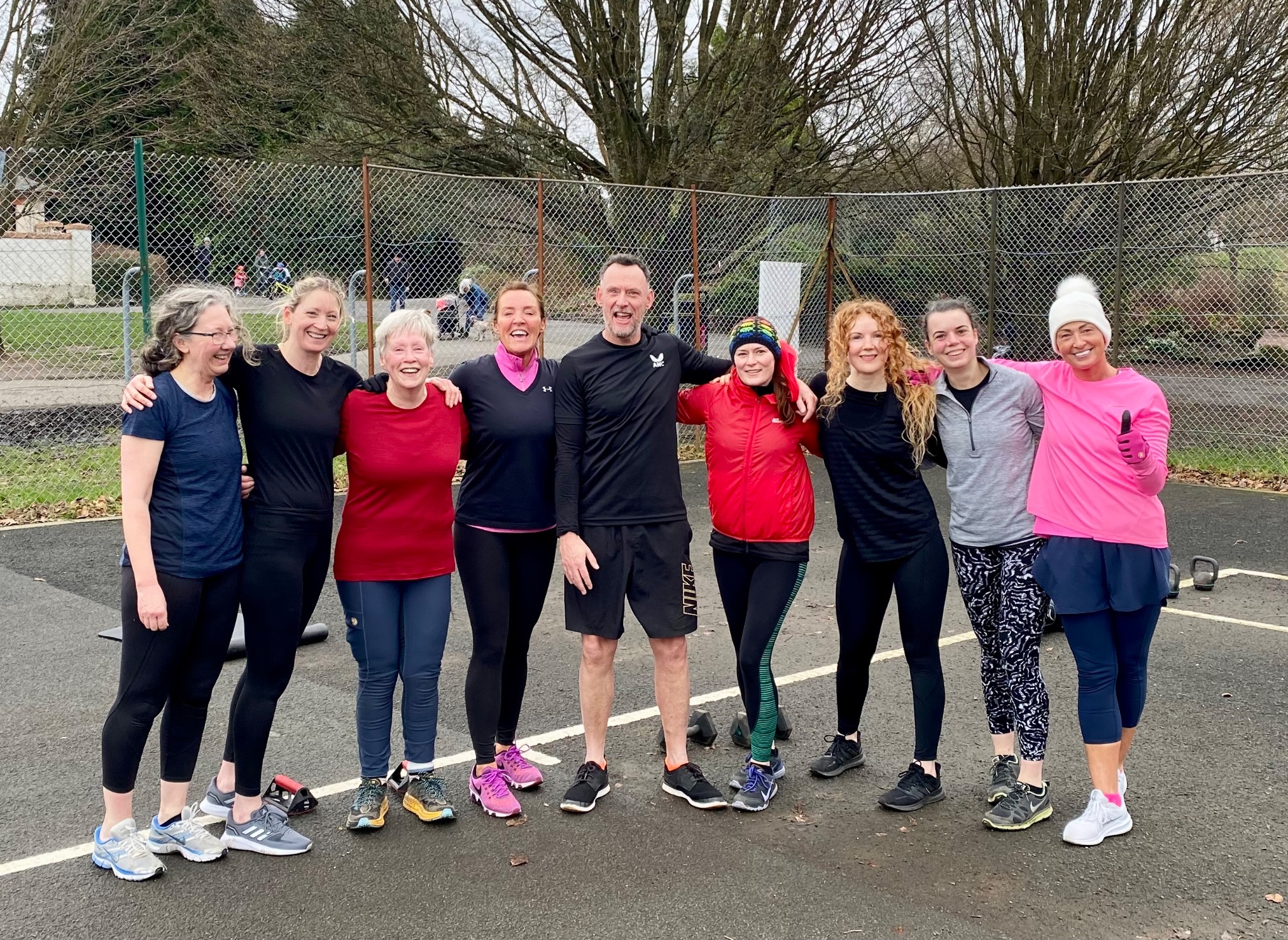 Members of the fitness community standing together outdoors after exercise