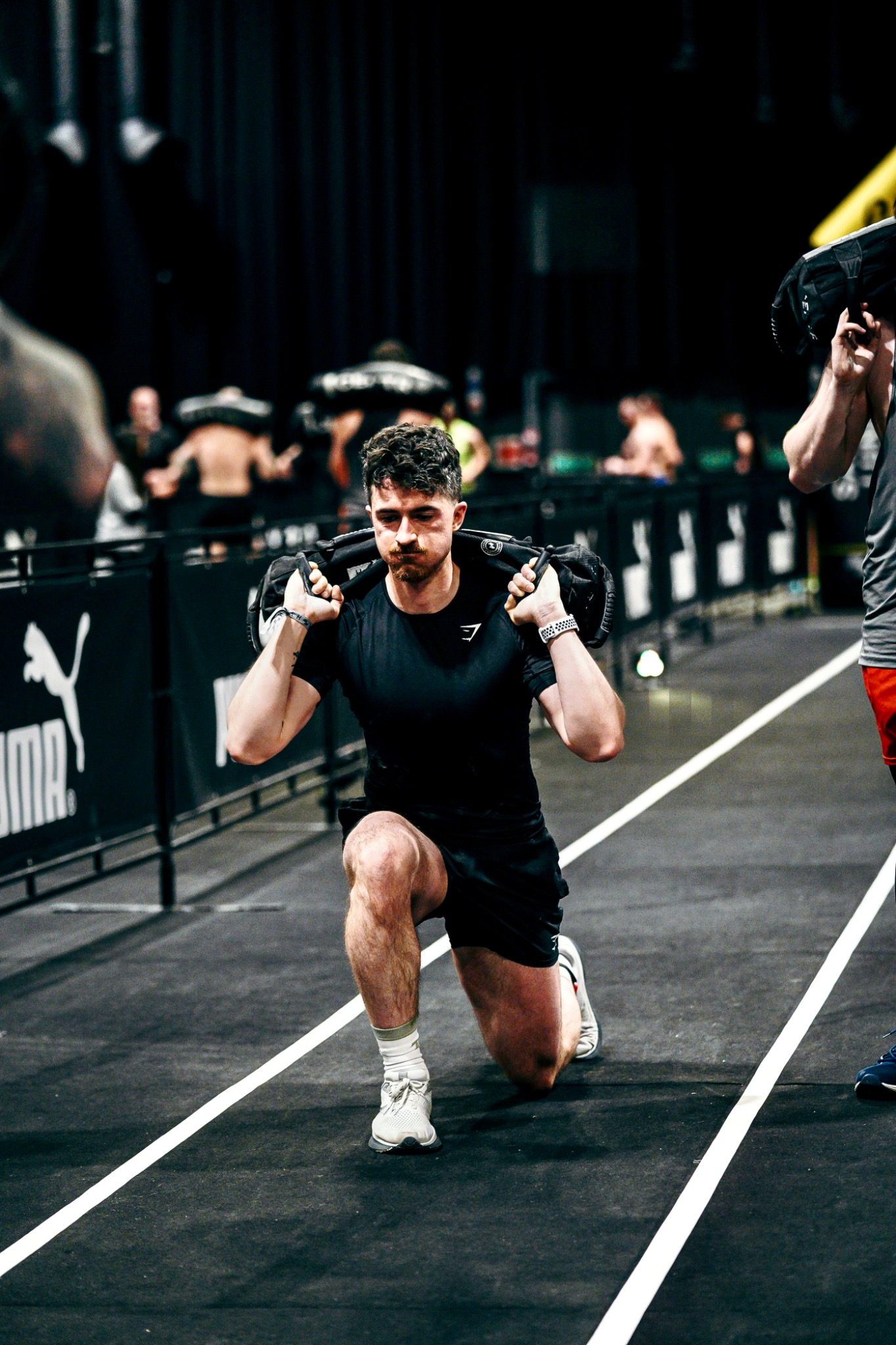 Michael performing sandbag lunges during a HYROX event